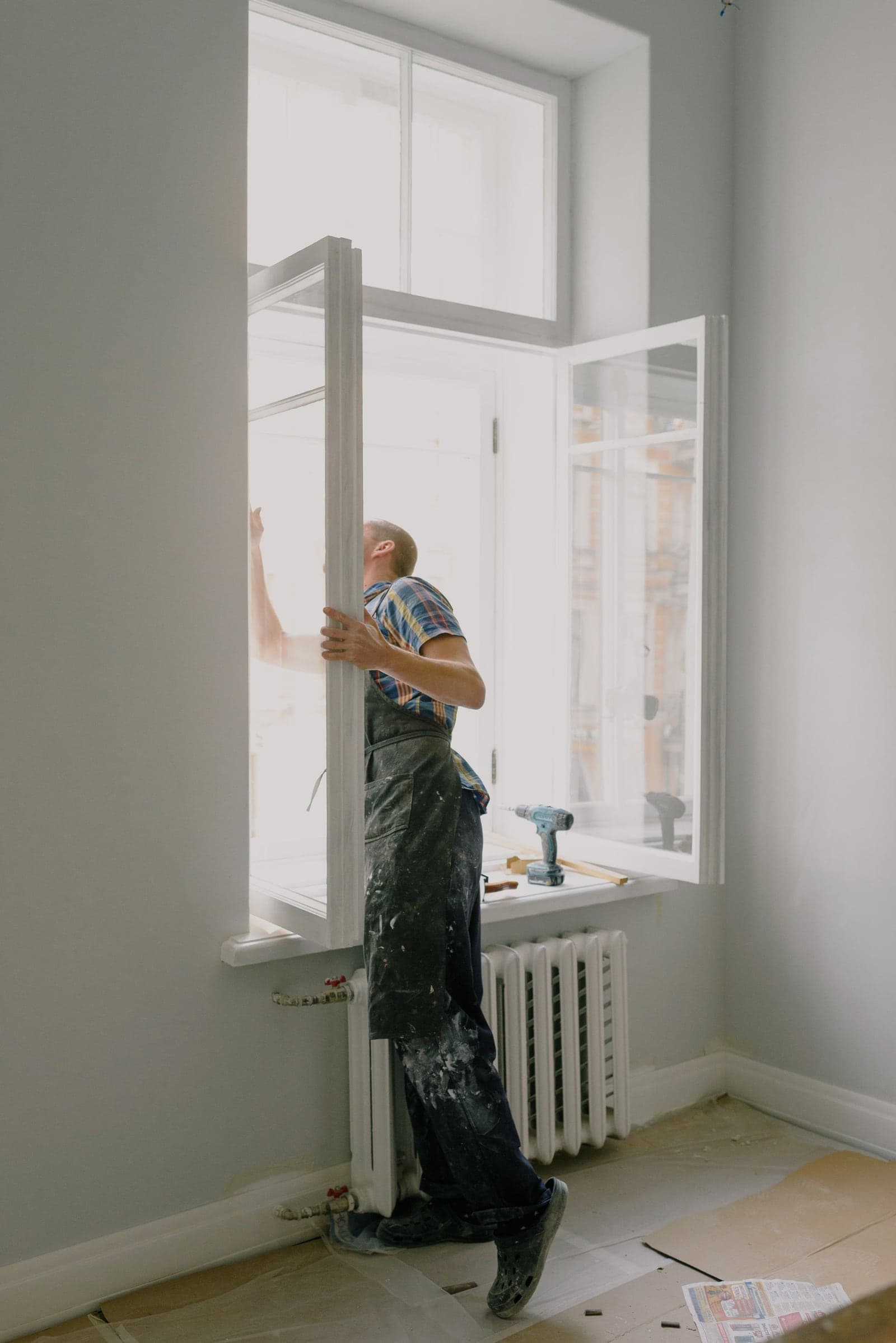 Instalador ajustando una ventana en su marco durante la instalación profesional