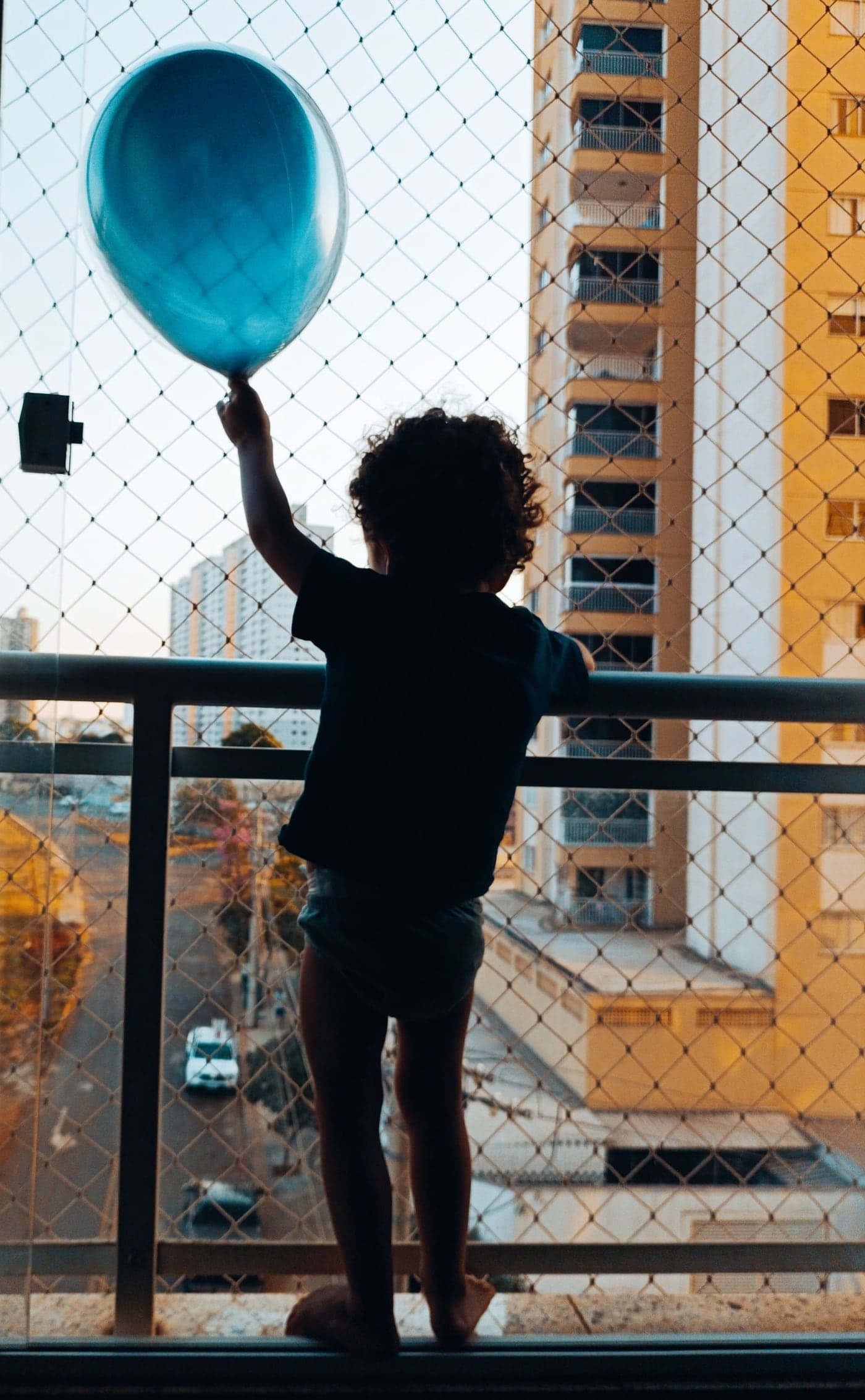 Niño protegido por una malla de seguridad en el balcón de un departamento en altura