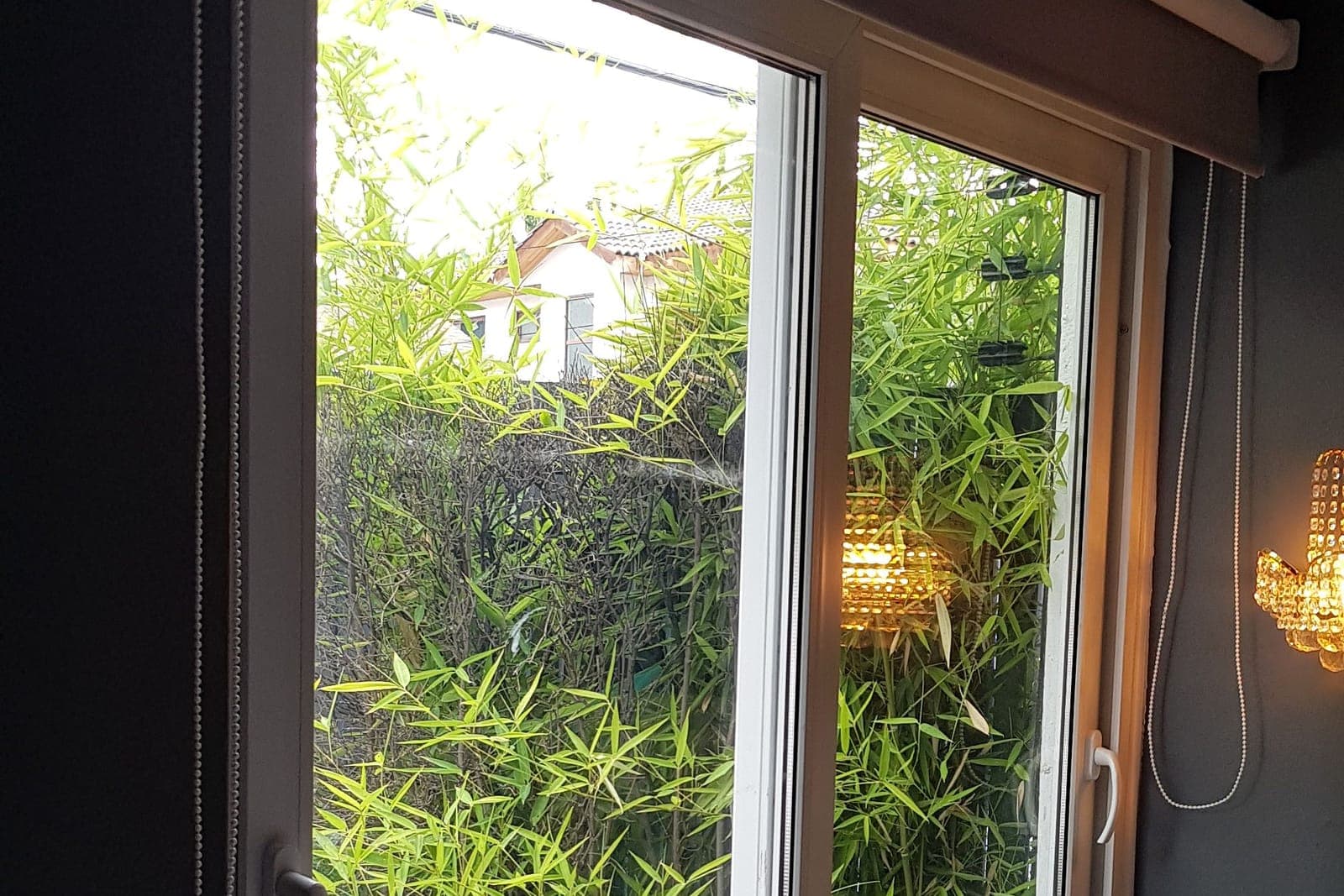 Ventana corredera PVC blanca con termopanel y vista a jardín