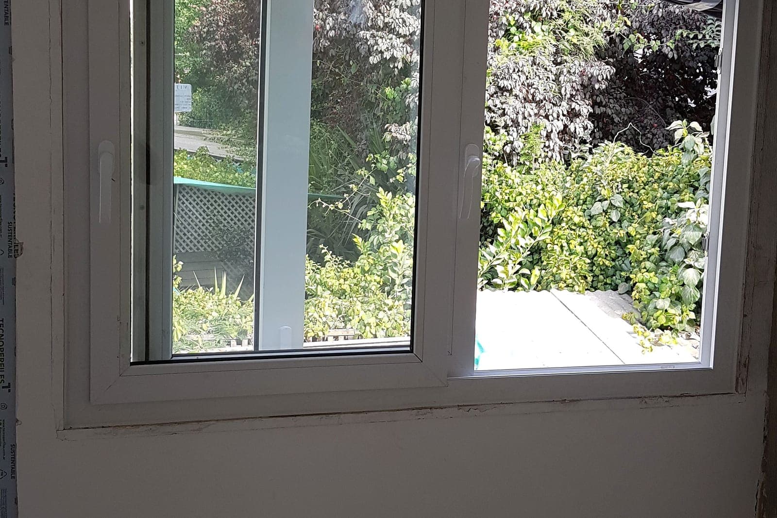 Ventana PVC blanca con termopanel y vista a jardín en Providencia