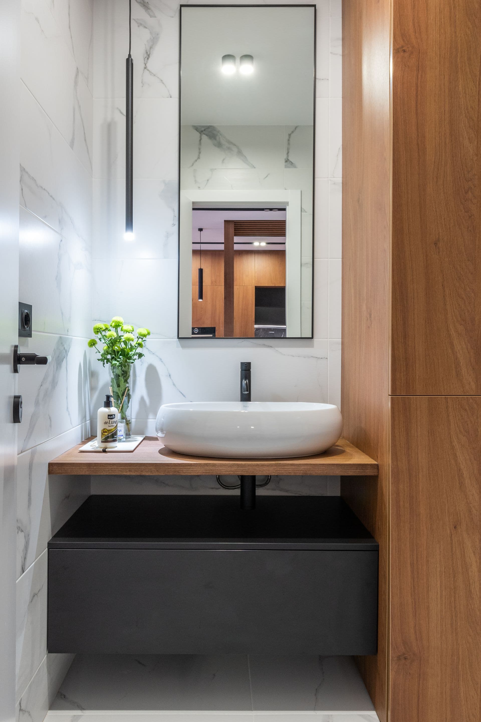 Baño de mármol y madera con grifería negra