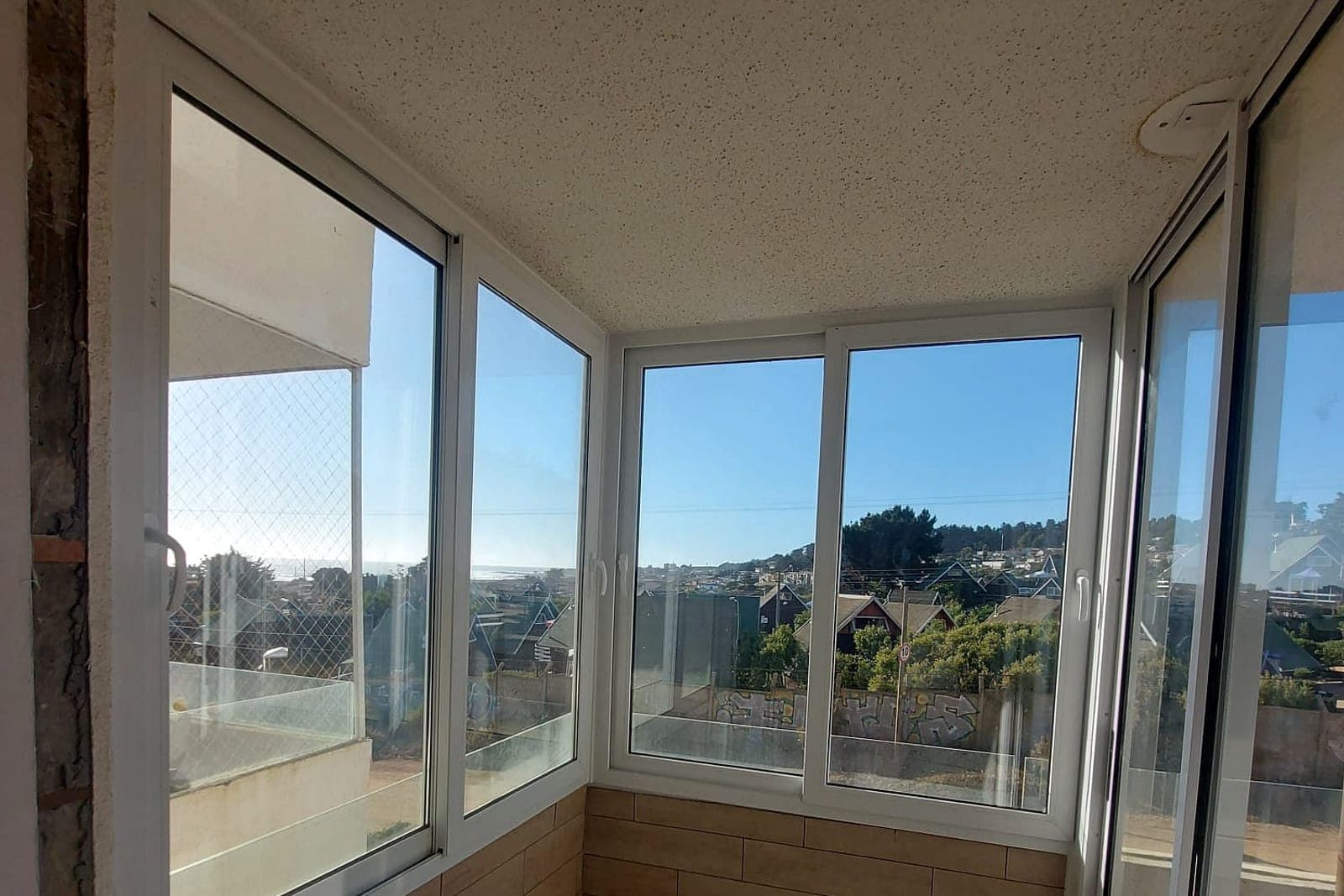 Cierre de terraza con ventanas PVC blancas frente al mar en El Tabo