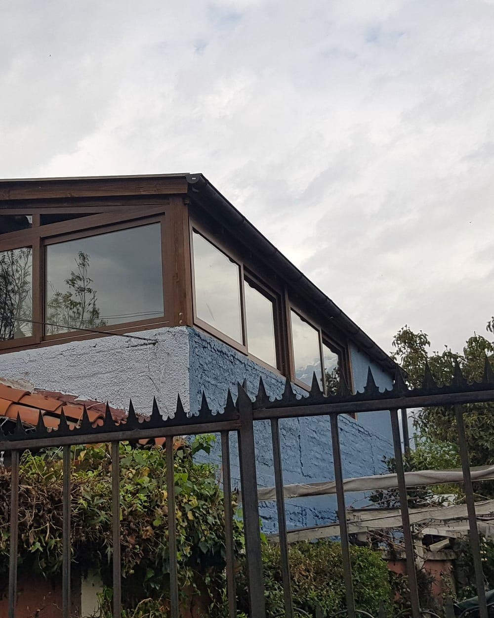 Ventanas continuas bajo alero de madera en una casa de La Reina