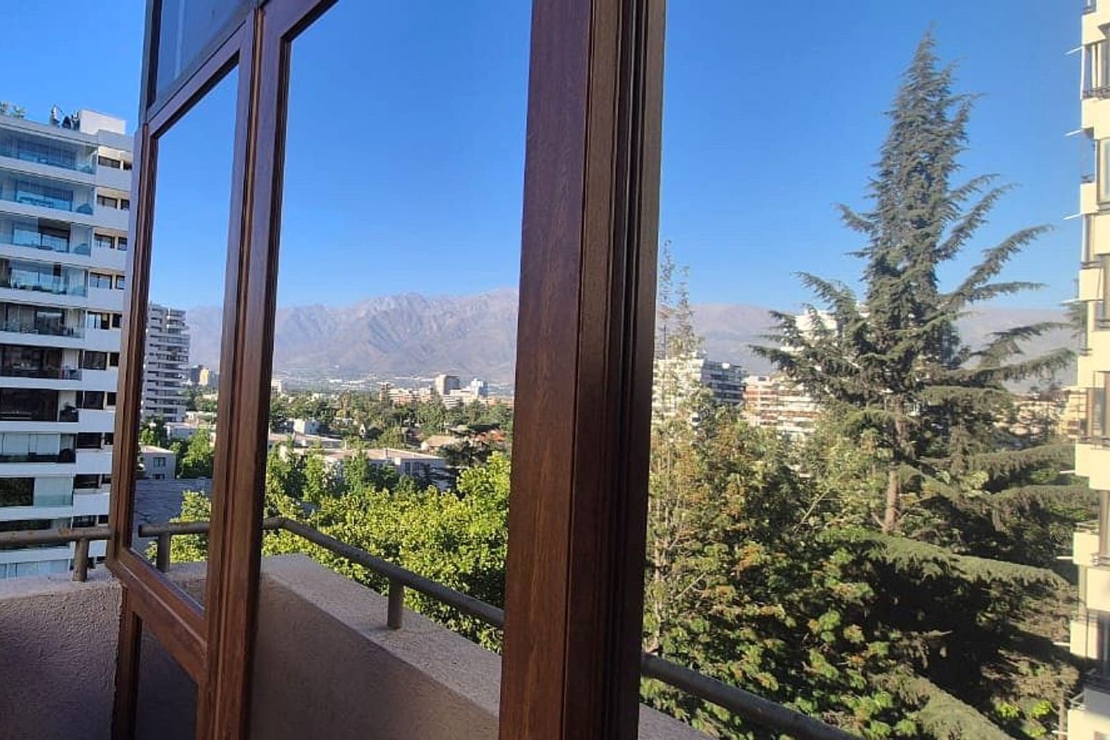 Ventana PVC nogal con termopanel y vista a la cordillera en Las Condes