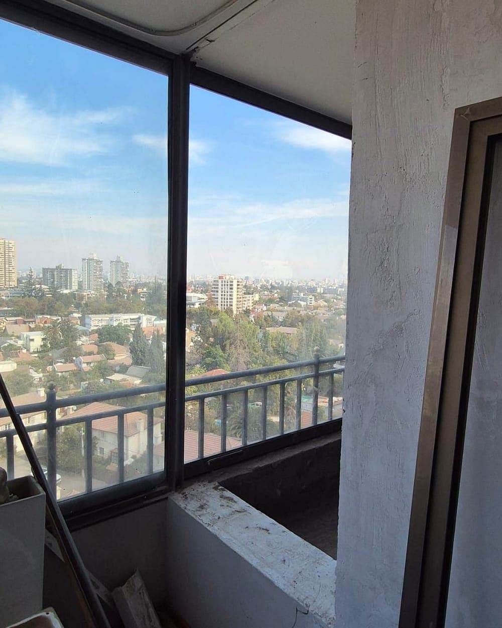 Ventanal de esquina con vista a la ciudad en un departamento de Las Condes