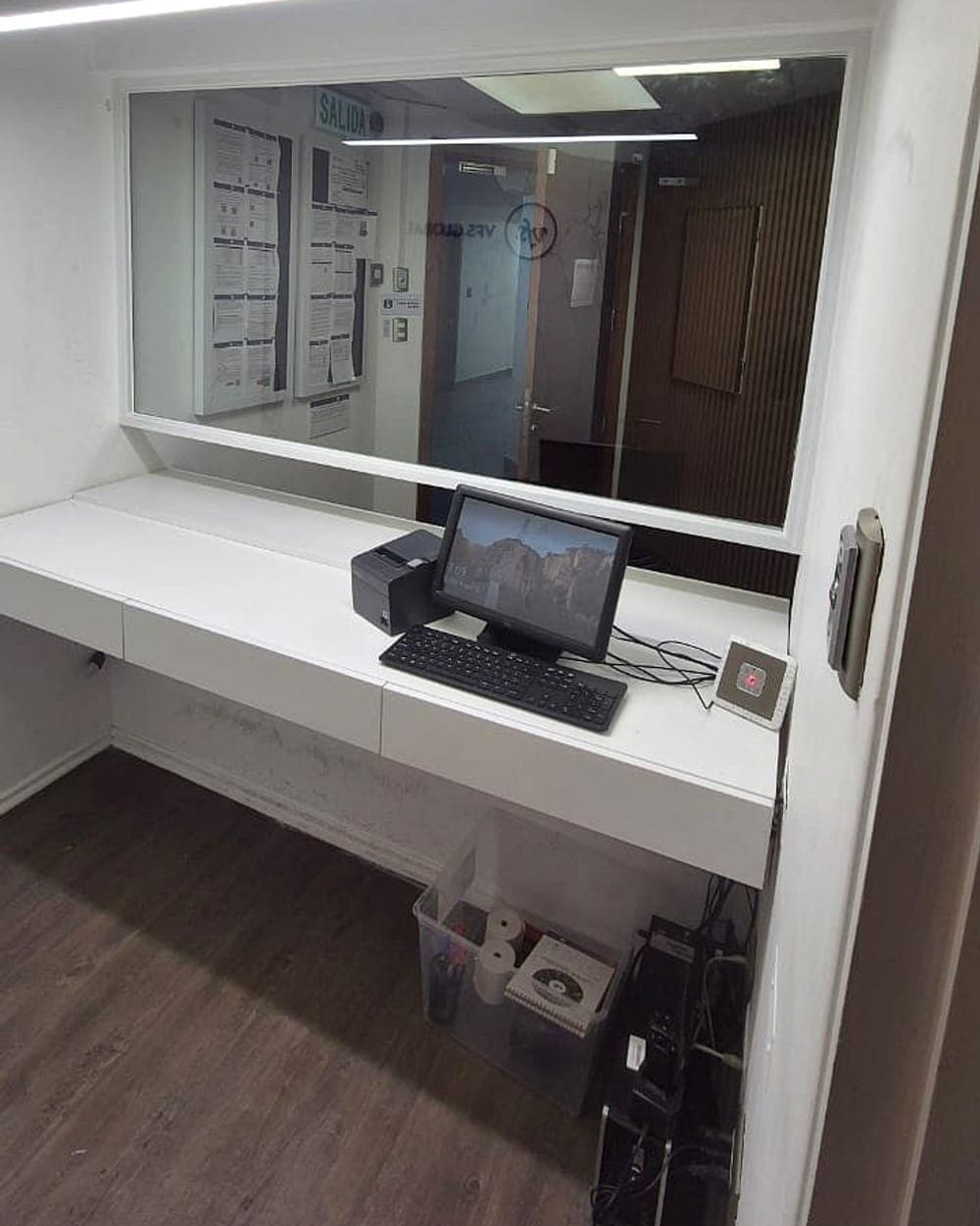 Mesón de atención con cristal y ventanilla en oficinas VFS Global
