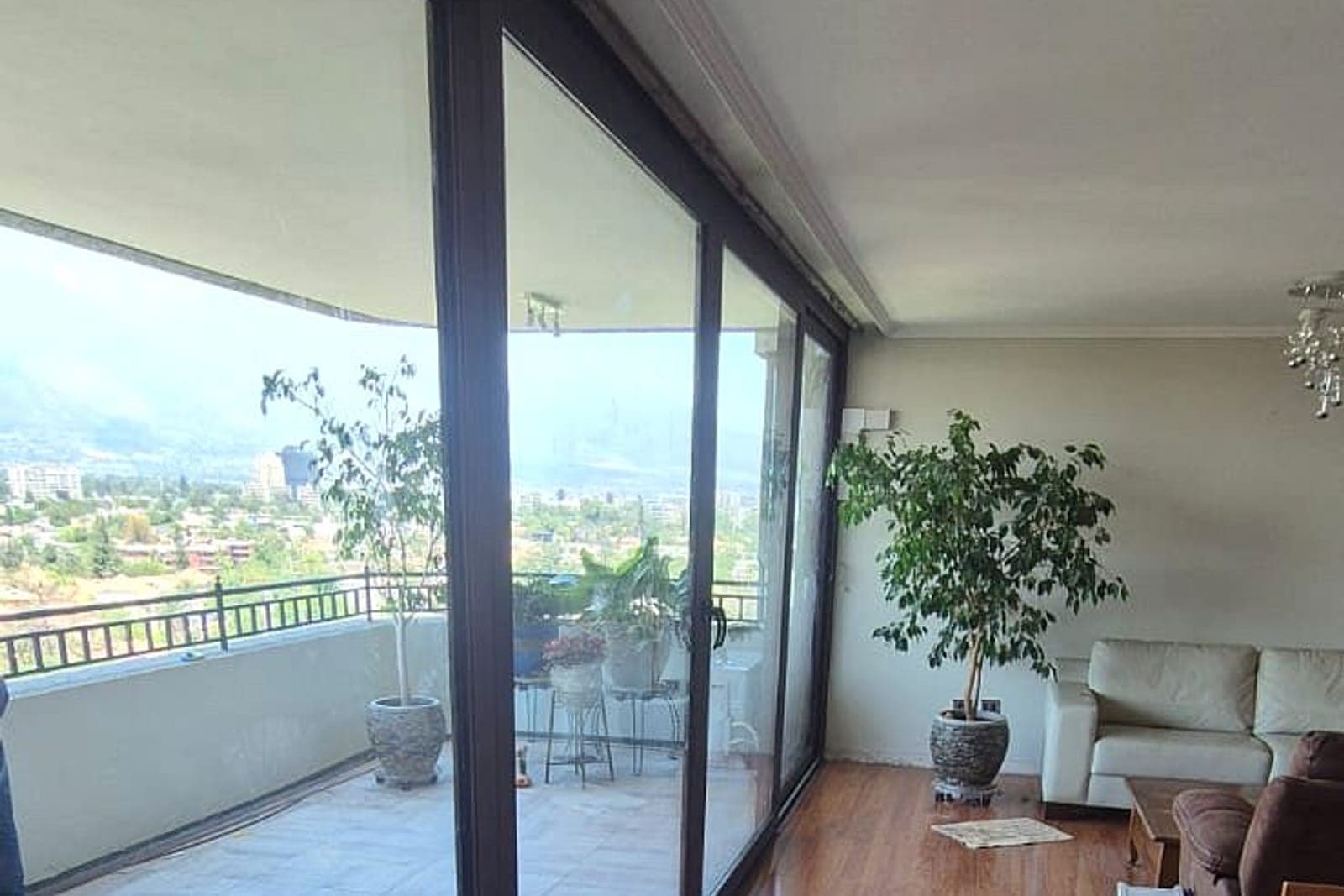 Living con terraza cerrada en cristal y vista panorámica de Santiago