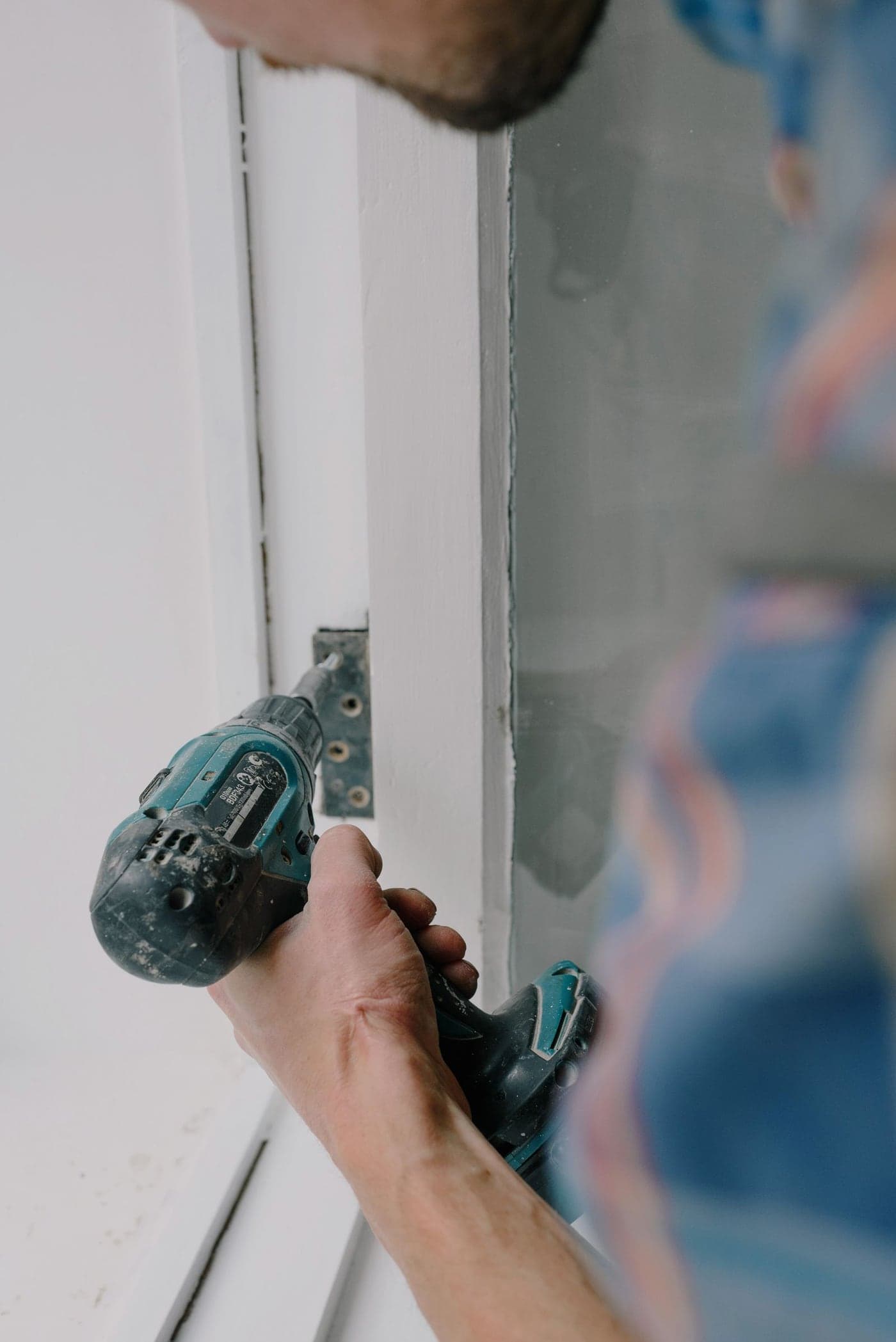 Instalador ajustando con precisión la bisagra de una ventana a medida